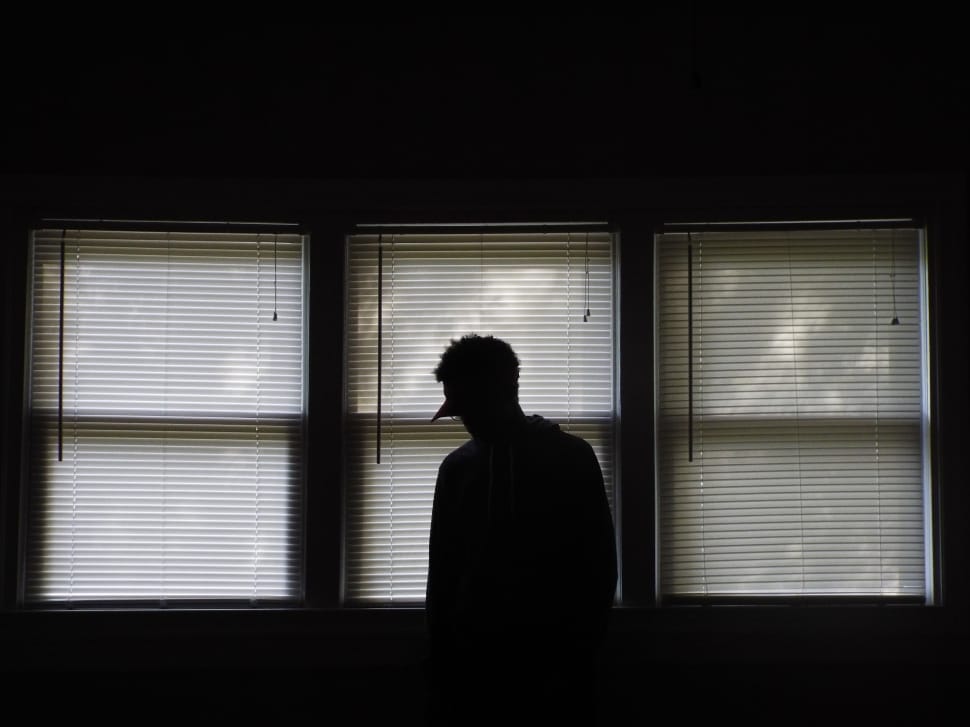Silhouette of a person standing by a window