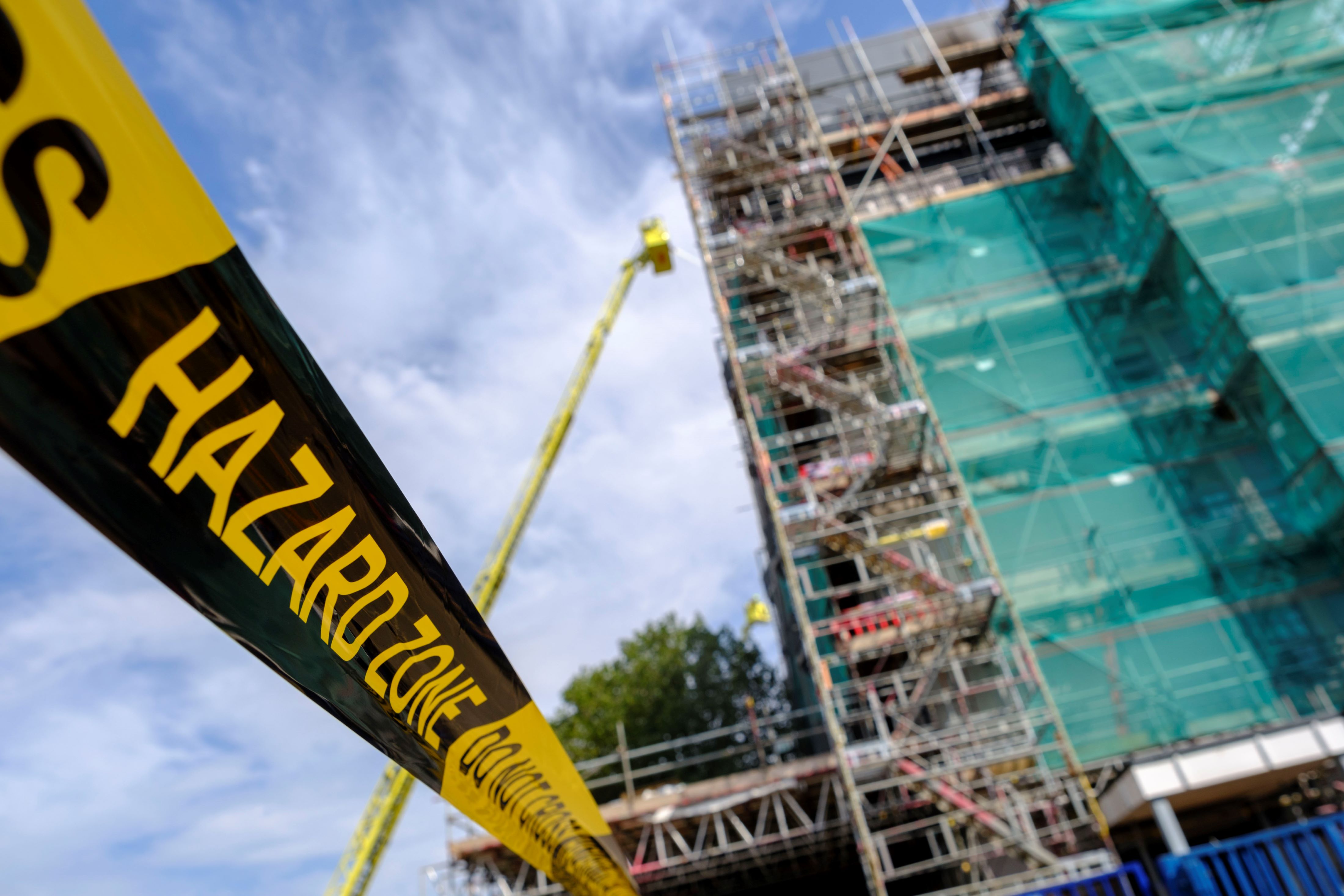 Hazard tape in front of burned block of flats in Dagenham