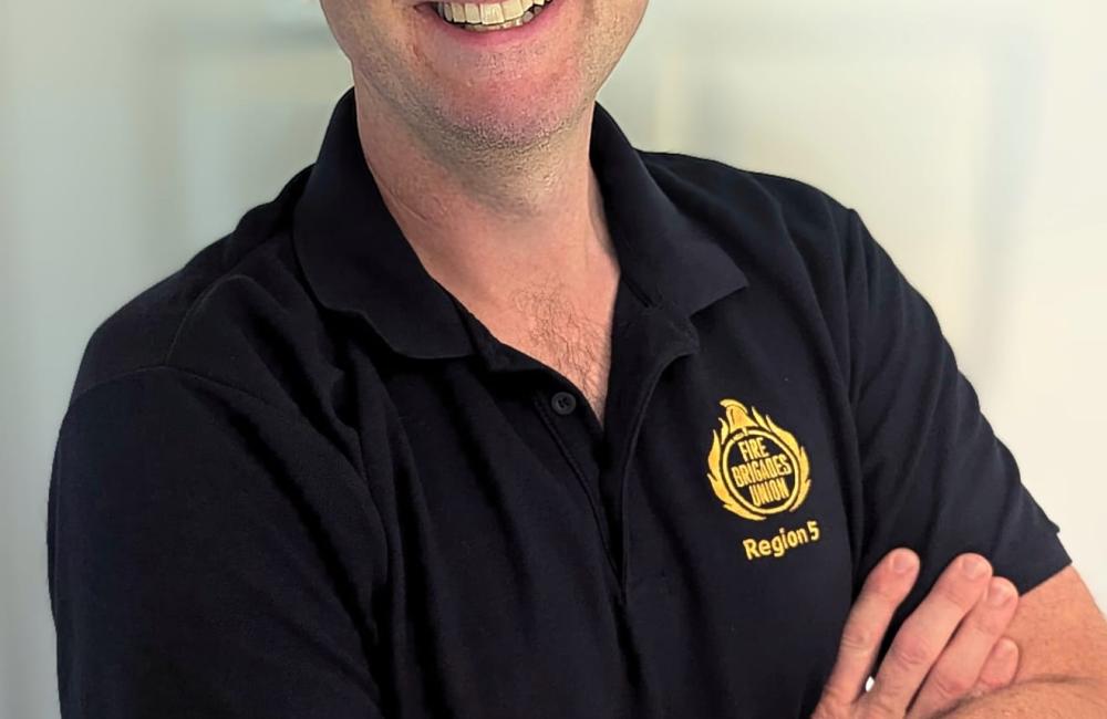 Matthew Black smiling at camera wearing FBU polo shirt