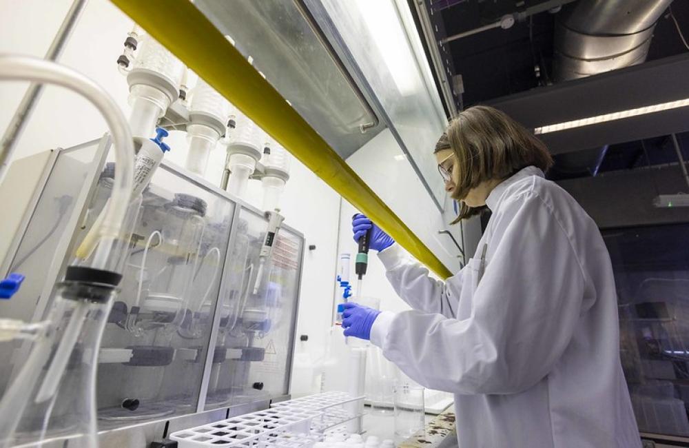 A scientist in lab coat tests samples in a lab