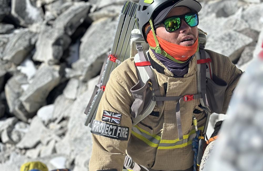 Firefighter in kit climbing a mountain