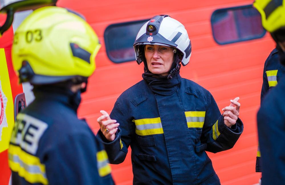 A firefighter talks to fellow women firefighters