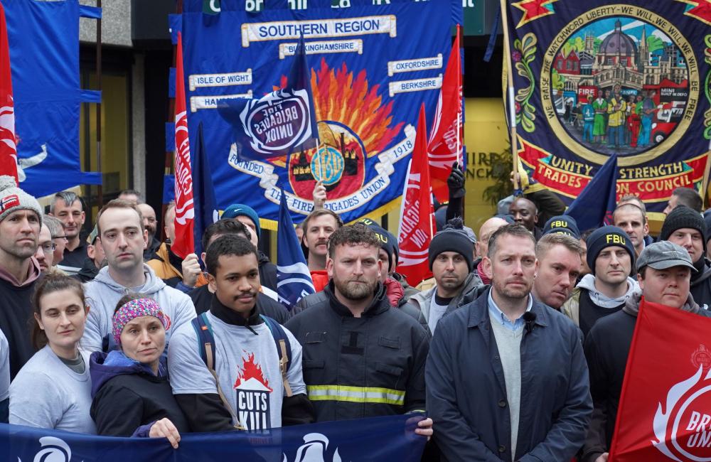 A crowd of firefighters with banners outside Oxfordshire county hall