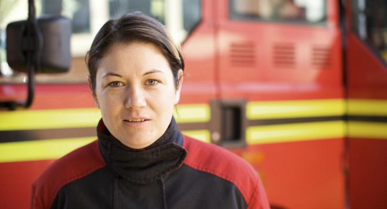 female firefighter in front of appliance