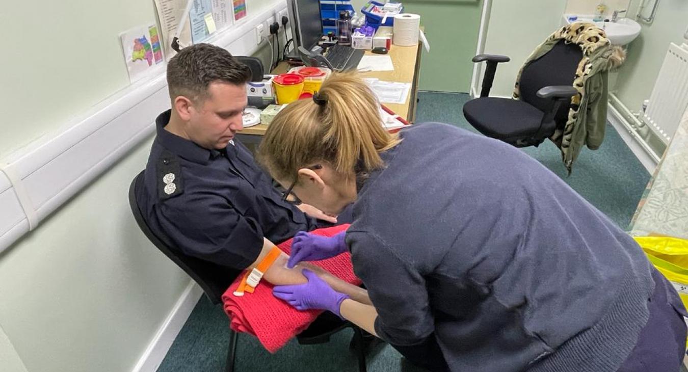 Firefighter having blood sample taken
