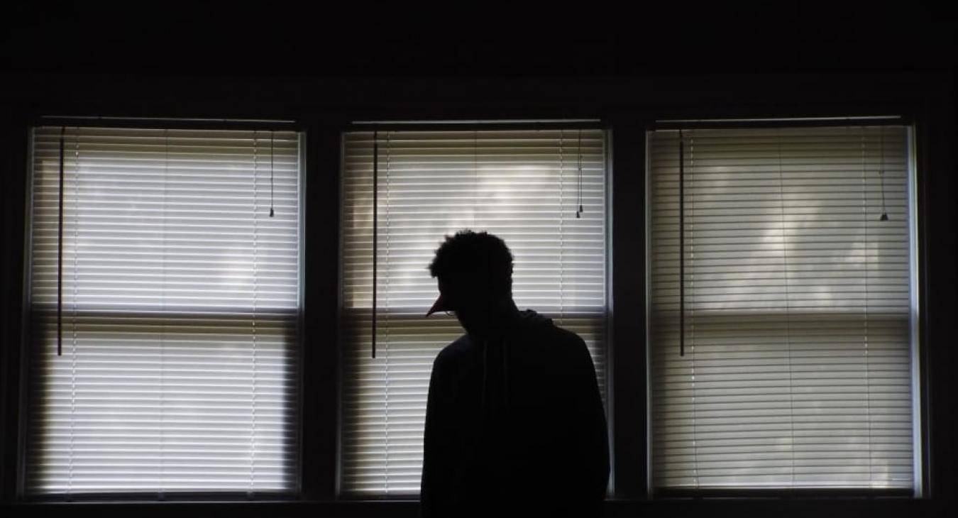 Silhouette of a person standing by a window